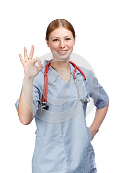 Happy young woman in blue surgical coat with red stethoscope and