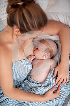 Happy young woman breastfeeding and hugging baby. Lactation newborn concept