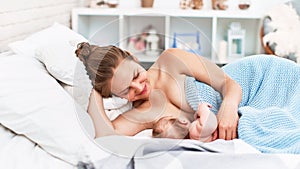 Happy young woman breastfeeding and hugging baby. Lactation newborn concept