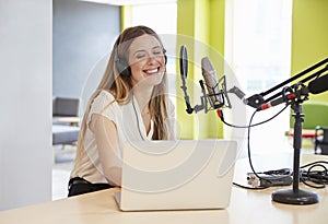 Happy young woman broadcasting in a studio, close up