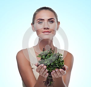 Happy young woman with a bundle of fresh mint. Concept vegetarian dieting - healthy food