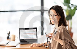 Happy young woman business analyst using laptop photo