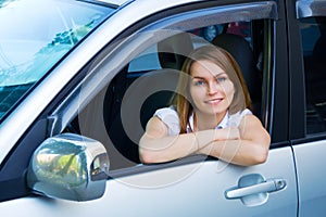 Happy young woman in a car