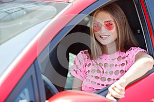 Happy young woman with a car