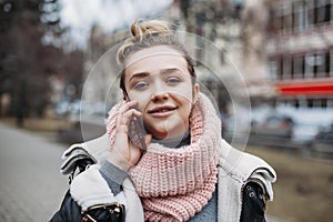 Happy young woman in casual walking while talking over phone. Cheerful girl using smartphone talking on phone outdoor