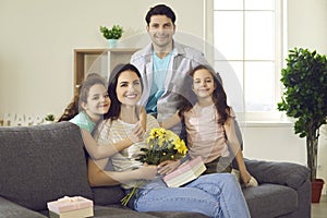 Happy young woman celebrating Mothers Day at home together with her loving family