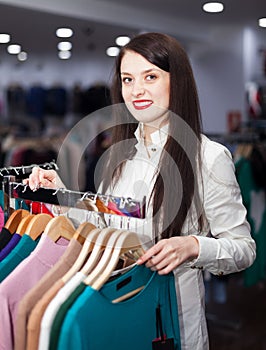 Happy young woman choosing clothes
