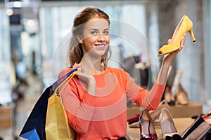 Happy young woman choosing shoes at store