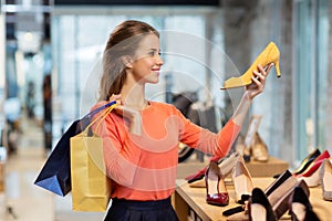 Happy young woman choosing shoes at store