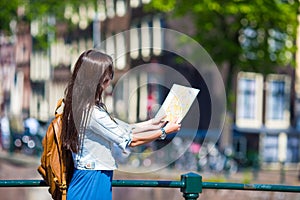 Happy young woman with a city map and backpack in