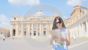 Happy young woman with city map in Vatican city and St. Peter`s Basilica church, Rome, Italy. Travel tourist woman with