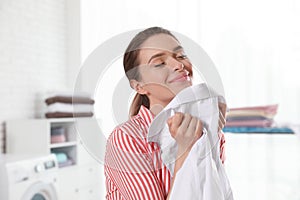 Happy young woman with clean shirt indoors