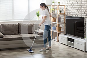 Young Woman Cleaning The Hardwood Floor photo