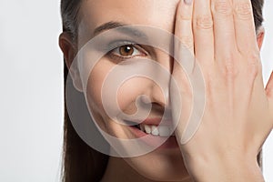 Happy young woman closing eye by hand