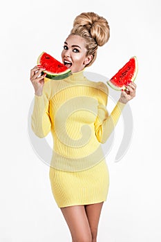 Happy young woman in colored dress holding slice of a watermelon  isolated over white background. Beautiful fashion model  holds