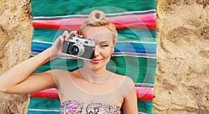 Happy young woman with colorful details lying on the beach and t