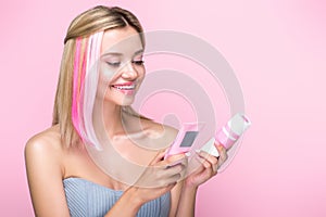 happy young woman with colorful hair strands holding hair treatments