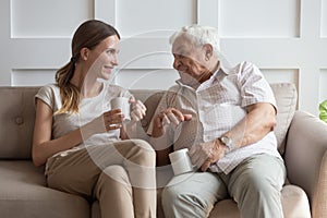 Happy young woman communicating with smiling old father.