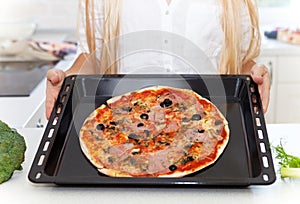 Happy Young Woman Cooking Pizza at Home