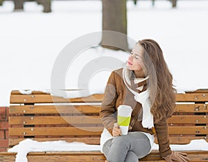 Happy young woman with cup of hot beverage enjoying winter