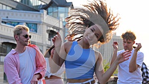 Happy young woman dancing and jumping while enjoying the music on the open air party on the rooftop. Lifestyle, fun