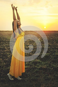 Happy young woman dancing and praising nature. photo