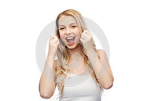 Happy young woman with dental floss cleaning teeth