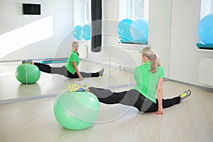 Happy young woman does exercise with fitball in photo