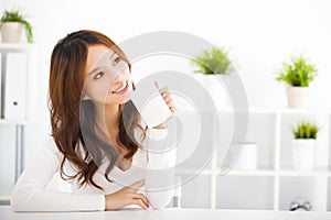 Happy young woman drinking coffee