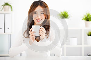 Happy young woman drinking coffee