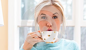 Happy young woman drinking coffee