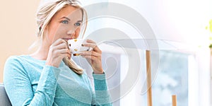 Happy young woman drinking coffee