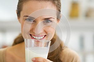 Happy young woman drinking milk