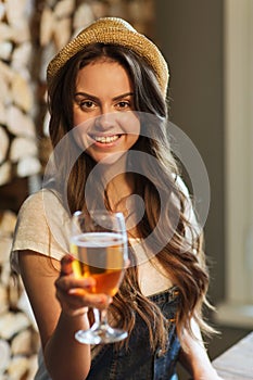 Happy young woman drinking water at bar or pub