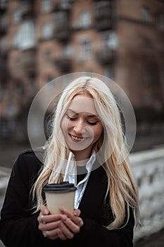 happy young woman drinks coffee in break. girl take coffee and go to work
