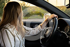 Happy young woman driving car. Business woman checking road automobile. Unsafely risky driving multitasking