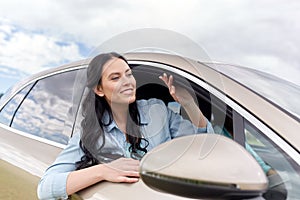 Happy young woman driving in car