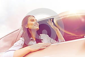 Happy young woman driving in car