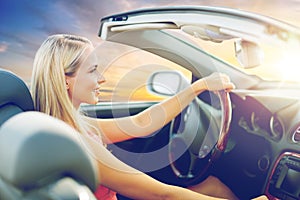 Happy young woman driving convertible car