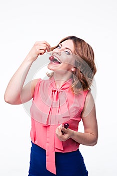 Happy young woman eating cherry