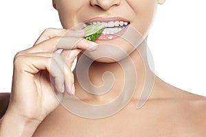 Happy young woman eating cucumber. Healthy smile with white teeth