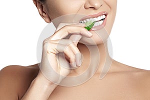 Happy young woman eating cucumber. Healthy smile with white teeth