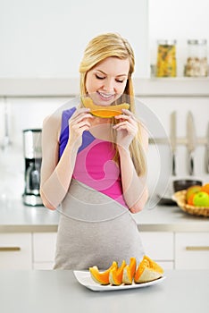 Happy young woman eating slice of melon