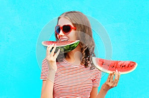 Happy young woman is eating slice of watermelon