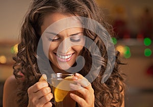Feliz mujer joven feliz bebiendo jengibre té limón 