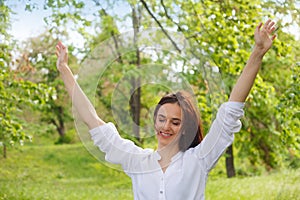 Happy young woman enjoying nature in a park