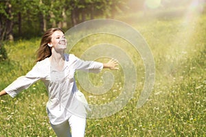 Happy Young Woman Enjoying Summer on the Green Meadow.