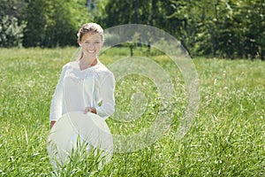 Happy Young Woman Enjoying Summer on the Green Meadow.