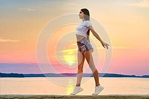 Happy young woman enjoys freedom in sunset time