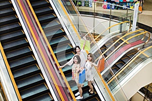 Happy young woman on escalator in shopping mall